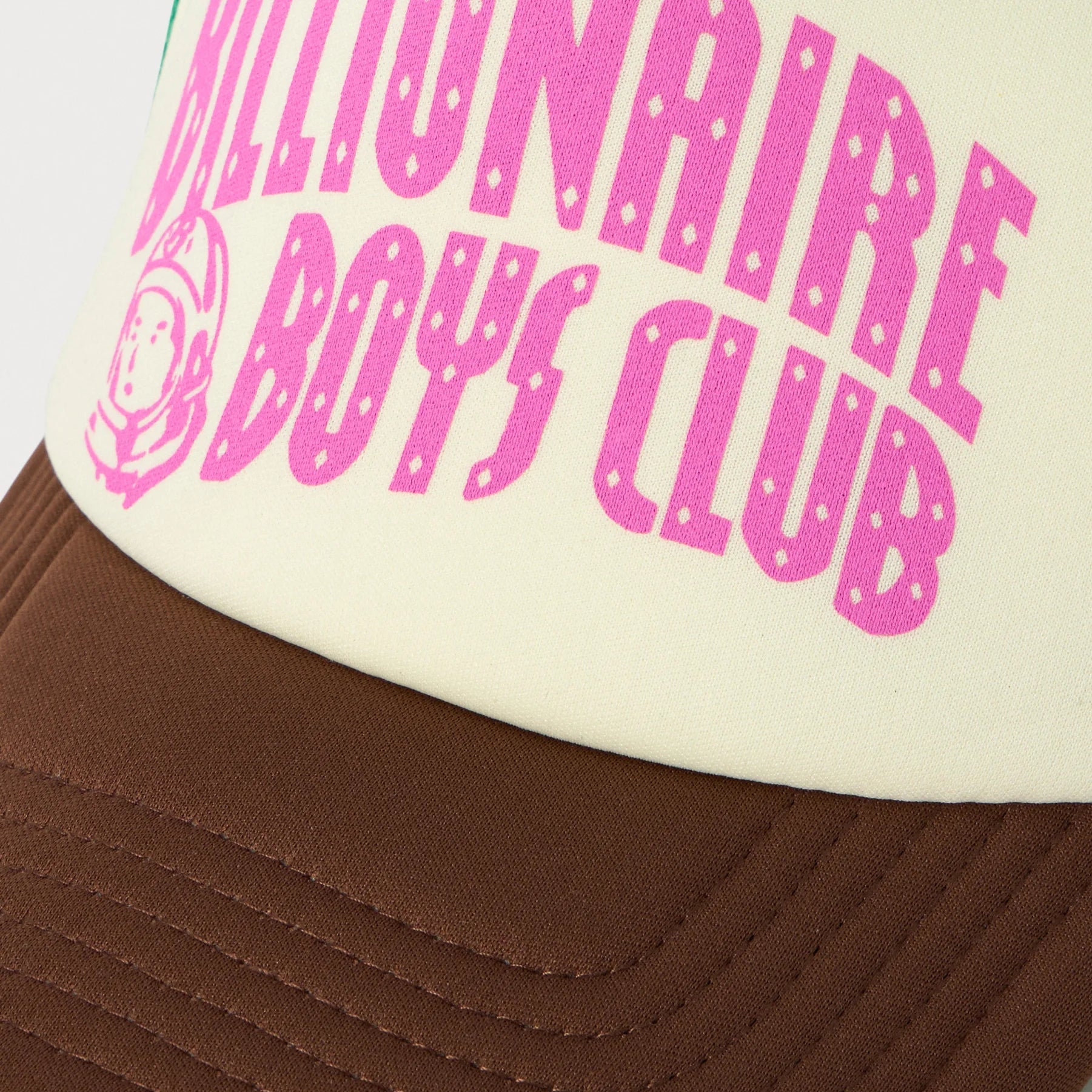 Trucker hat with 'Millionaire Boys Club' text in pink on a white background