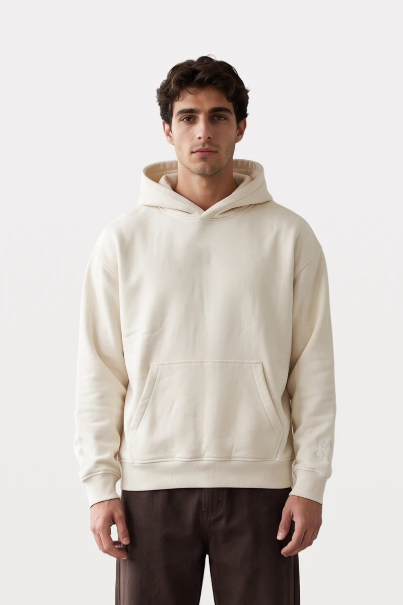 RAQI Essential Pullover Hoodie in creamy light beige featuring a spacious hood, kangaroo pocket, and ribbed cuffs.