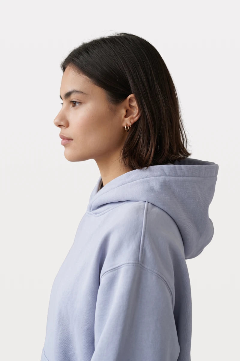 RAQI sky blue pullover hoodie with a structured hood worn by a woman in a side profile view