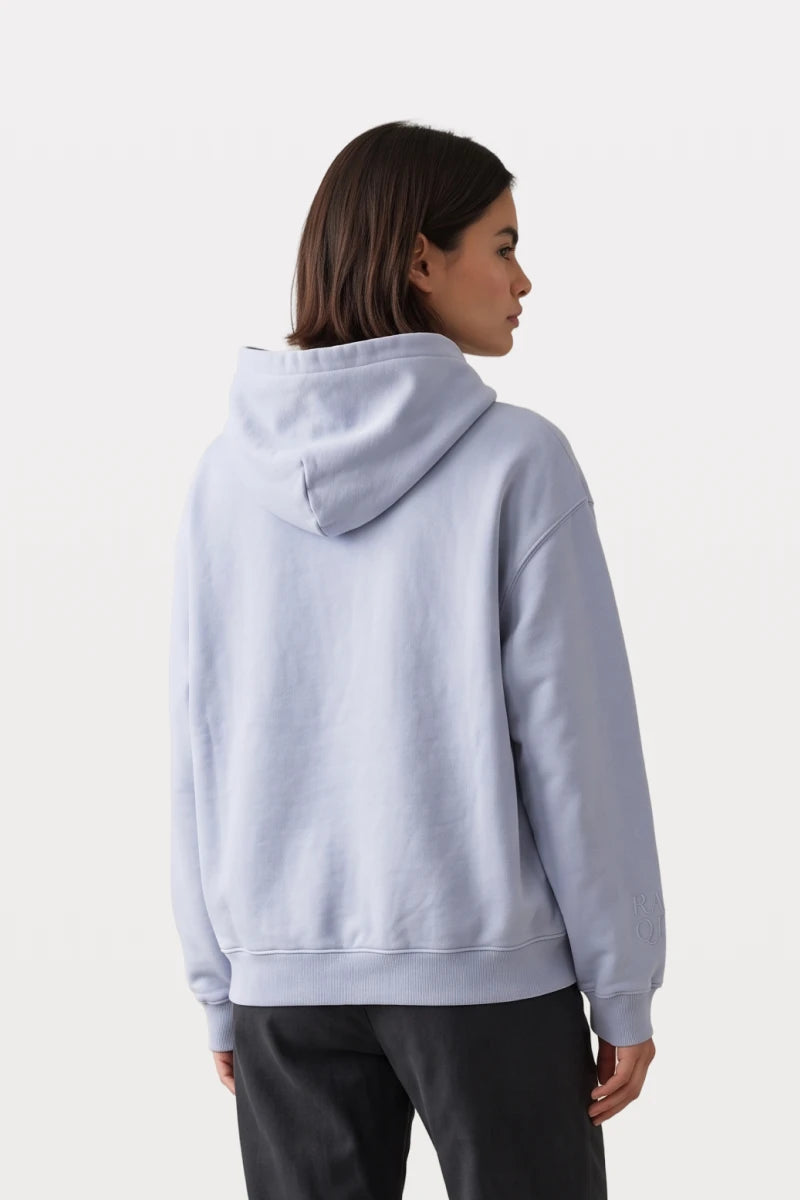 Woman wearing a RAQI sky blue pullover hoodie with a structured hood and tonal sleeve embroidery, back view